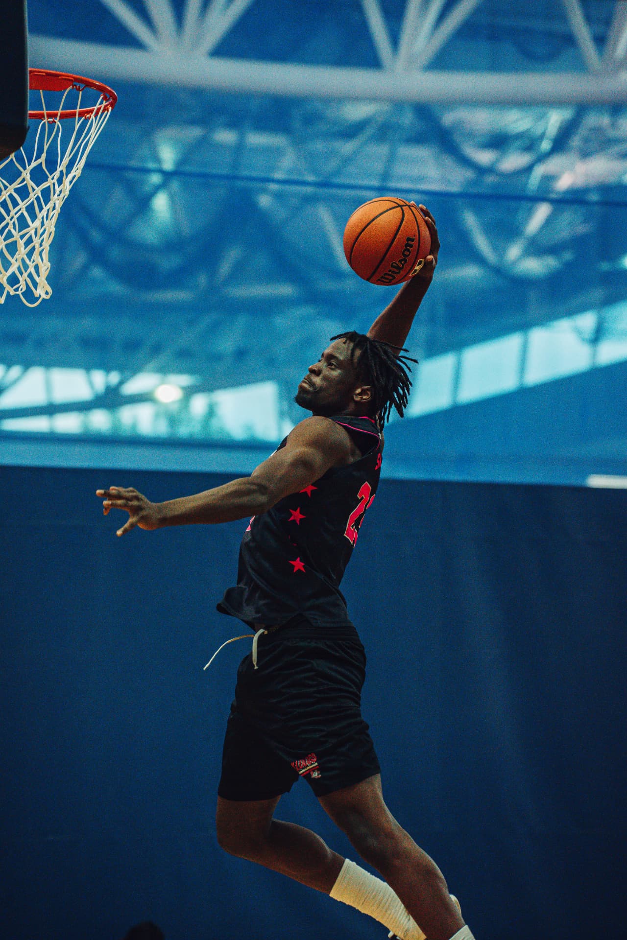 Player rising for a one-handed dunk at HOOPS 4 HOPES