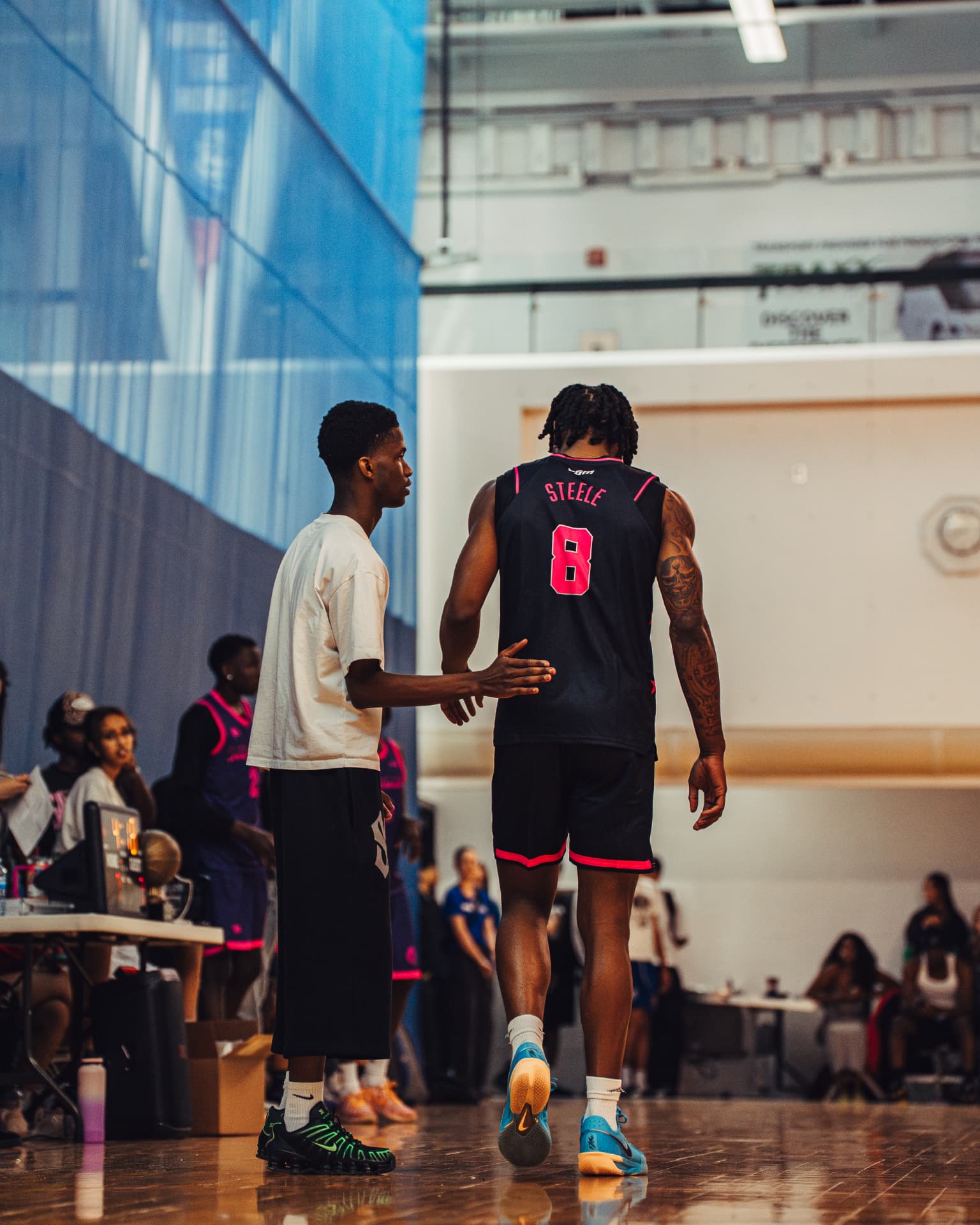 Player Steele greeting a teammate on the sideline