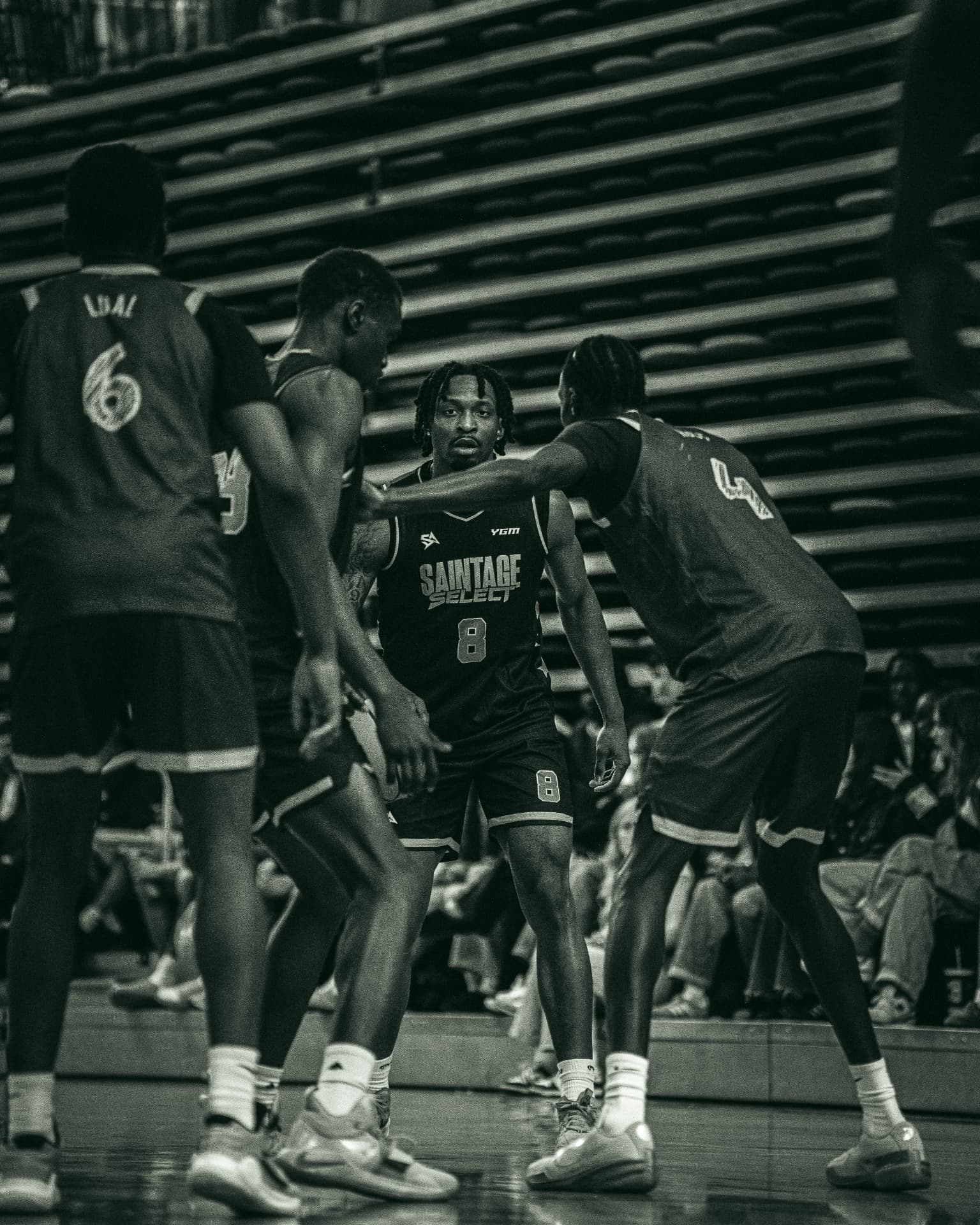Black and white photo of SAINTAGE Select player number 8 surrounded by defenders
